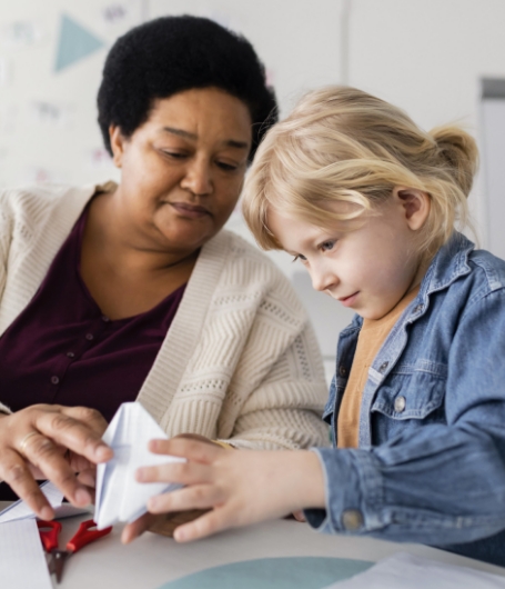 Teacher working with a young girl.
